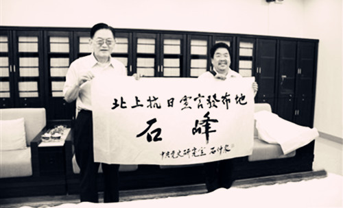 中国侨网2012年4月29日，中央党史研究室原副主任、著名党史专家石仲泉(左)委托当地人管其乾，将他为北上抗日宣言发布地石峰村题字转交石峰村两委。(赖晓斌 摄)
