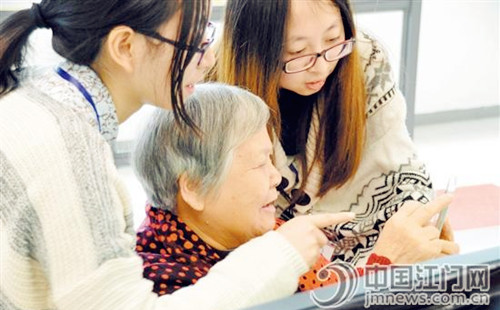 社工们教老人学玩微信。