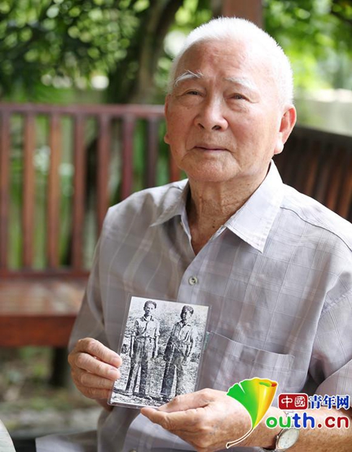 86岁的王声手拿13岁时参加抗日远征军的照片(左侧为其本人),向记者讲述少年参军抗日的烽火岁月。中国青年网记者