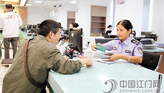 在江门市白沙街“邑门式”服务中心公安综合窗口,工作人员为居民办理户政业务。