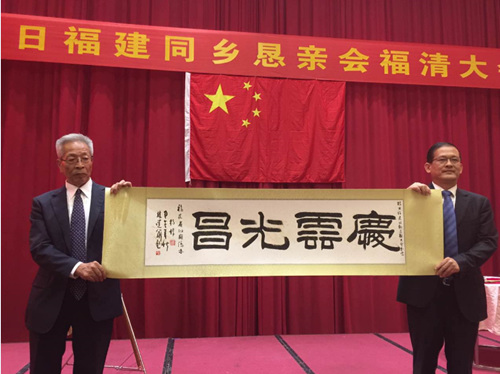 图(1):省侨办杨辉主任像大会执行委员会林文明赠送书法