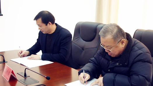 李文忠先生(右)与熊儿寨乡党委书记刘万岭签约(吕文宝