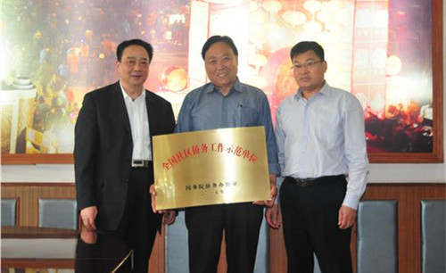 徐州市委统战部副部长、市侨办主任李明(左1)为马庄村授牌。