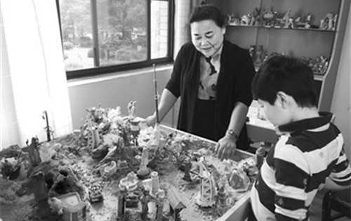 在长沙西湖社区办公楼内的金老师工作室,侨眷金利君正在用“沙盘疗法”为社区里的孩子做心理咨询。