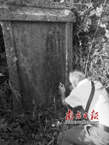 在村民指引下找到一块清朝桥碑后，年逾古稀的张仁敏蹲在地上仔细察看碑上的文字。南方日报记者