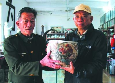 中国侨网孙剑魂（右）将古玩捐赠给东山闽台民俗馆馆长林财平。