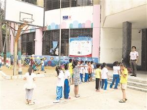 中国侨网新阳希望学校的学生在狭小的水泥地操场上,准备上体育课。