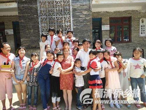 中国侨网庄桂淦与学生一起拍合照。（图片来源：福清新闻网）