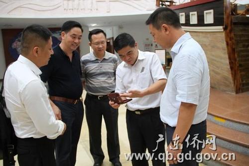 中国侨网郑建民副主任(中)、广东华侨博物馆馆长王明惠(右二)与朱金亮会长(右一)等仔细研看收藏品
