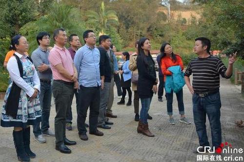 中国侨网望谟县热作产业良种繁育科技示范园负责人向欧美同学会代表团介绍情况。(摄影:杨丽芳)
