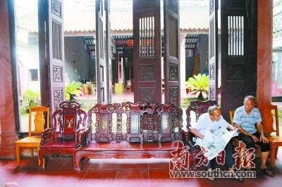 中国侨网2001年,为进一步保护保养宗祠,黄氏后人再次集资进行重修。图为村民在黄氏宗祠内看报纸休闲。 南方日报记者 孙俊杰 摄