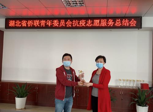 中国侨网万颖向志愿者们颁发了荣誉证书和奖杯。（湖北省侨联网站）