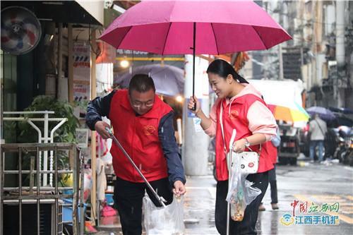 中国侨网黄申萍（左）冒雨捡拾垃圾（记者 罗建华摄）