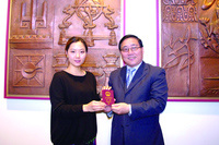 李华新总领事和首位获发电子护照的刘璐合影。（澳洲《星岛日报》）