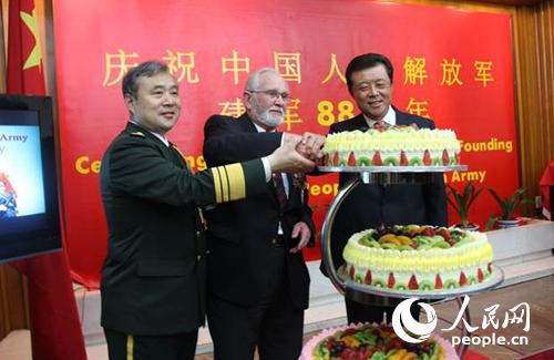 刘晓明大使（右一）、姚珉少将（左一）与英国诺曼底登陆老兵乔治·巴茨（中）一起切庆祝蛋糕。李应齐摄