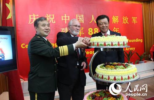 刘晓明大使(右一)、姚珉少将(左一)与英国诺曼底登陆老兵乔治·巴茨(中)一起切庆祝蛋糕。李应齐摄