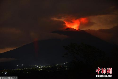 中国侨网印尼巴厘岛阿贡火山自11月21日首次喷发后，活跃强度不断增强并多次喷发出大量火山灰。图为当地时间11月30日拂晓前的阿贡火山烟雾染红天际。