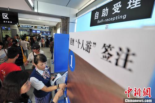 中国侨网 资料图:广西南宁市公安局出入境管理分局启用自助办理厅,内设自助填表机、自助受理机、自助发证机和电子触摸查询设备。中新社发 洪坚鹏 摄