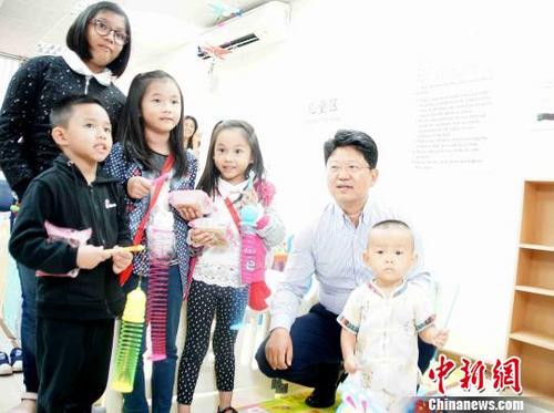 中国侨网白天大使（右二）向现场的小朋友分赠月饼和中秋提灯，送上中秋祝福。　陈悦　摄