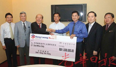 邝汉光(右3)移交百万令吉捐献予吴德芳(左3),由方天兴(中)见证。(马来西亚《光华日报》)