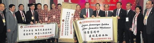 印度尼西亚客属联谊总会、雅加达客属联谊会、印度尼西亚梅州会馆领导赠送间距给西加客家联谊会后合影。(印尼《星洲日报》)