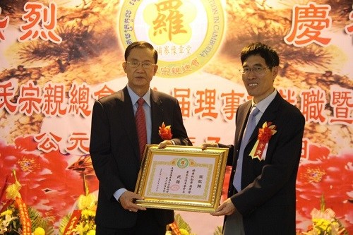 中国驻柬大使馆领事部主任杨庆连（右）向柬华理事总会会长杨启秋勋爵颁发最高永远名誉会长证书。（柬埔寨《星洲日报》）