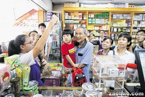 82岁的谢荣明(中)携孙子参与中药学习之旅时,聆听加东修道院女校的“小导游”分享基本中药知识和药行的历史。(新加坡《联合早报》/龙国雄