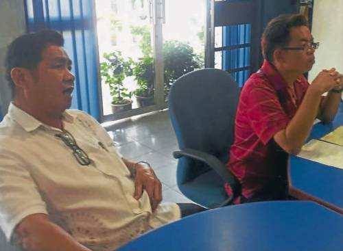 蔡同财(左)陪同林伟良向波德申警方报案。(马来西亚《南洋商报》)