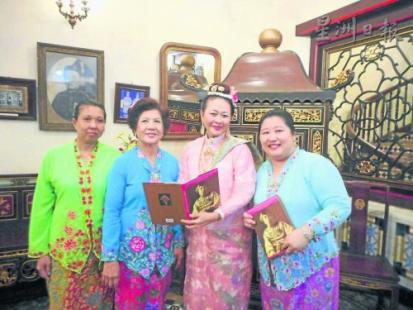 穿上传统QQ娘惹服装及佩戴娘惹首饰的博物馆负责人，右二为唐宝玲。（马来西亚《星洲日报》）