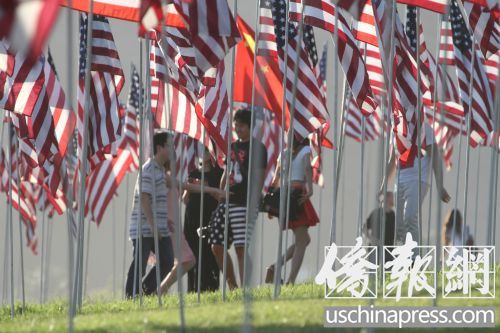中国侨网一群中国留学生及中国游客在星条旗旗海中的五星红旗下聚会。（邱晨 摄）