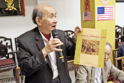 中国侨网华工筑铁路150周年,庆祝会筹委会主任伍璇灿展示特刊。(美国《世界日报》/关文杰 摄)