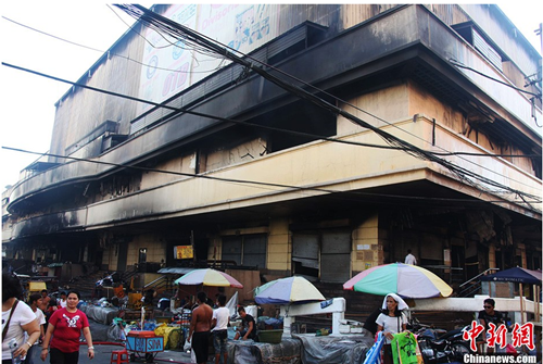 中国侨网2013年5月19日，位于菲律宾首都马尼拉华人区的利未素惹商场（New Divisoria Mall）火灾现场仍有黑烟冒出，整座商场几乎被烧成一片废墟。