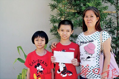 中国侨网何桦泽与母亲陈丽琼及妹妹何桦铿分享考获6A的喜悦。（马来西亚《光华日报》）