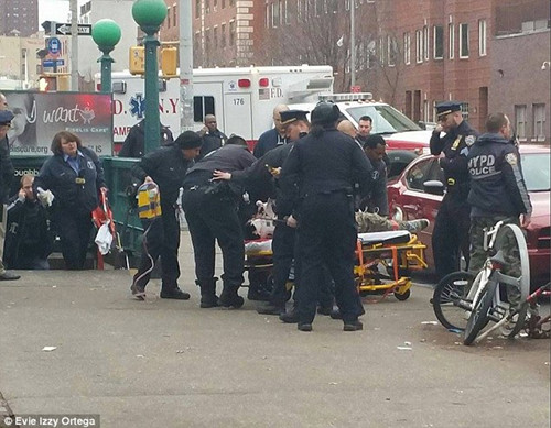 中国侨网图为警察将据信是枪手的男子抬上担架,该名男子在枪杀两名警察后向自己开枪。(美国中文网)