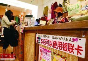 中国侨网资料图片：日本冲绳一家商场为吸引中国游客购物，贴出可以使用银联卡消费的标识。