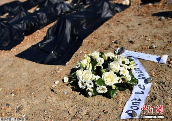 中国侨网 当地时间2015年4月22日，英国布莱顿，海边，活动者在海滩放置200个黑色的装尸袋并躺入其中，呼吁人们关注倾覆移民船遇难者。  