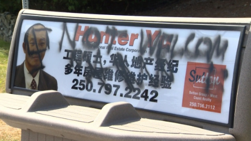 中国侨网乃磨华裔地产经纪徐孙(Xu Sun 译音)在长凳上的广告被喷上种族歧视字眼,脸上有纳粹标志。(加拿大《世界日报》)