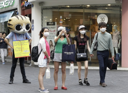 中国侨网韩国的MERS疫情，对旅游业造成很大冲击，图为在首尔街头，游客戴口罩游览。(美国《世界日报》)