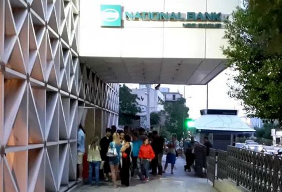 中国侨网希腊雅典民众28日晚在银行ATM取款机前排队等待取款。（希腊欧联通讯社/雷迅 摄）