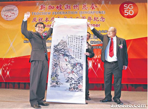 中国侨网潮州总会署理会长黄南德(右)代表总会赠送一幅名为《匡庐仰止》的水墨画给教育部长王瑞杰。这幅画由本地水墨画家莫雪琴所画,书法家洪云生题字。洪云生也是义安公司董事。(新加坡《联合早报》/邬福梁 摄)