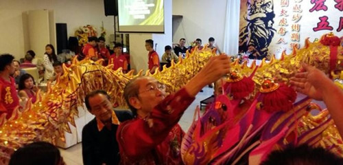 古晋宏扬龙狮团五周年庆祝晚宴主宾天猛公刘金荣为祥龙点晴。（马来西亚《诗华日报》）