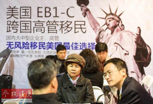 一家公司工作人员在北京春季房展会向参观者介绍海外投资移民情况。(参考消息)