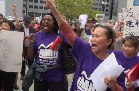 近日华人居民在华盛顿唐人街社区集结起来抗议房屋所有者的拆迁计划。（视频截屏）