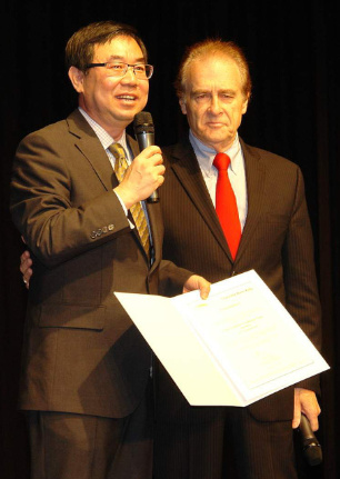 多伦多市议员凯利（右）颁发市府贺函予主办的加拿大新华人联合会会长杨海峰（左）。（加拿大《世界日报》/葛健生