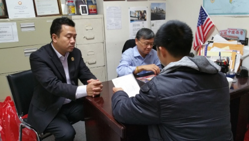 认为生意被Seamless制约的王先生(背对镜头者)至美国华人餐饮业协会法律咨询求助，左为陈键榕。(美国《世界日报》/许雅钧