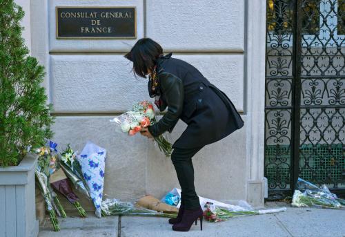 纽约市民在法国驻纽约总领事馆门前摆放鲜花，悼念巴黎恐袭死难者。(美国《侨报》援引美联社)