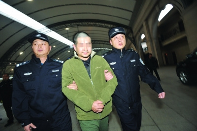 昨日,王某被押解回汉。来源:荆楚网