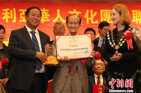 澳洲中国和平统一促进会会长黄向墨（左1）向获得澳华文化界杰出贡献奖的黄庆辉先生（中）颁奖。　赖海隆　摄