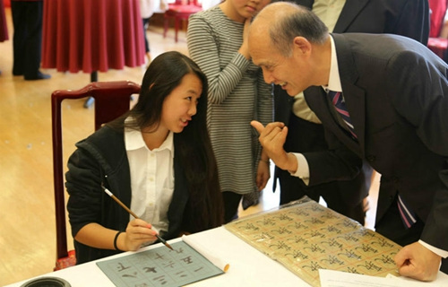 当地时间12月5日，中国驻旧金山总领事罗林泉（右）教被领养的孩子埃米莉·川田（左）读数字。（杨曦摄）