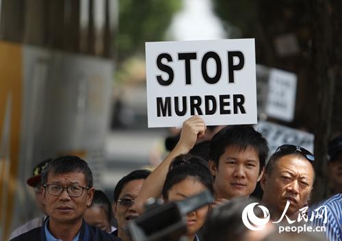 参与游行的华侨华人手举“停止谋杀”、“停止强奸”等标语。本网记者
